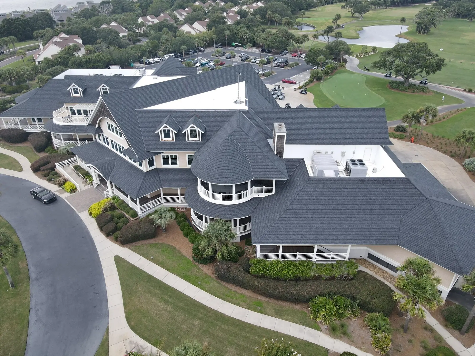 The building's got some serious Southern charm with that wraparound porch and dark roof