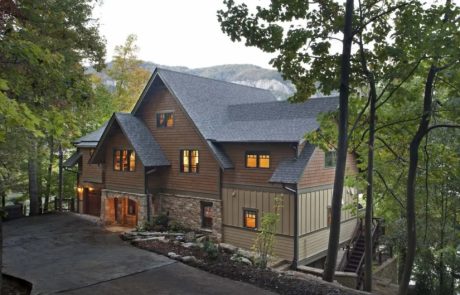 Looks like a super cozy mountain retreat! Brown wood siding, gray roof, and stone accents giving it that rustic vibe.